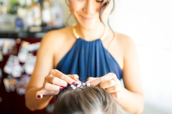 Coiffeuse faisant la coiffure de la future mariée